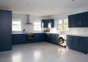 cocina grande con armarios azules y lavavajillas en Riverview Cottages, en Cookstown