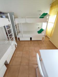 a room with two bunk beds and a table and chairs at Racing Mackerel Hostel in Lagos