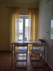 a table and chairs in a room with a window at Racing Mackerel Hostel in Lagos