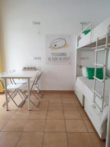 a dorm room with a desk and bunk beds at Racing Mackerel Hostel in Lagos