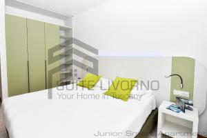 a bedroom with a white bed and a side table at Suites Marilia Apartments - Suite Livorno Holiday Home Group in Livorno