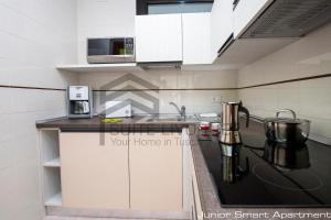a kitchen with white cabinets and a black counter top at Suites Marilia Apartments - Suite Livorno Holiday Home Group in Livorno