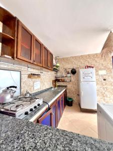 uma cozinha com um fogão e um frigorífico branco em Sunrise auberge surf tamraght em Taghazout