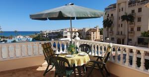 a table and chairs on a balcony with an umbrella at Villa Sandy Coast in El Moncayo