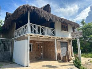 un ancien bâtiment avec un toit de paille dans l'établissement Nature Harmony Retreat in Tierra Bomba - Your Sustainable Escape, à Carthagène des Indes
