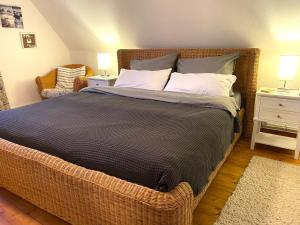 een slaapkamer met een groot bed met een rieten frame bij Ferienhaus Norddeichkieker in Norddeich