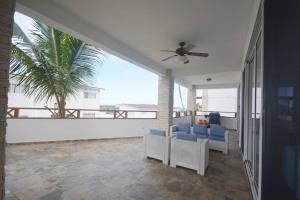 a patio with blue chairs and a view of the ocean at Magnifique appartement vue mer in Las Terrenas
