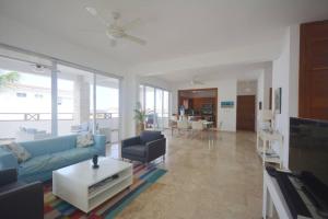 uma sala de estar com um sofá azul e uma mesa em Magnifique appartement vue mer em Las Terrenas