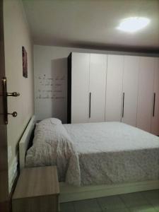 a bedroom with a bed and white cabinets at Lety's home in Sulmona