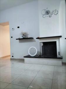 a living room with a fireplace and a white wall at Lety's home in Sulmona