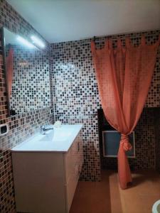 a bathroom with a sink and a red curtain at Lety's home in Sulmona