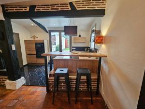 uma cozinha com um balcão com dois bancos num quarto em Le Sully, gîte aux portes de la Sologne em La Ferté-Saint-Aubin
