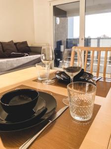 un tavolo in legno con piatti e bicchieri sopra di Studio Le Hésingue- Near Airport, Swiss & German board a Saint-Louis