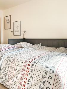 a bedroom with a bed with a quilt on it at Studio Le Hésingue- Near Airport, Swiss & German board in Saint-Louis