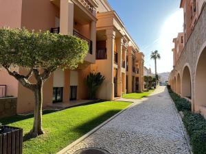 a walkway between two buildings with a tree in the middle at Margarida Apartment in Luz