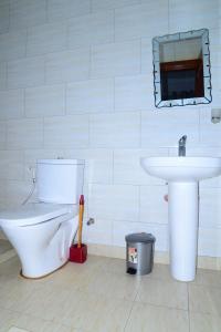 La salle de bains est pourvue de toilettes et d'un lavabo. dans l'établissement AIRPORT COMFORT APARTMENT MILITARY HOSPITAL, à Kigali