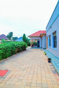 une maison avec une allée en pierre à côté d'un bâtiment dans l'établissement AIRPORT COMFORT APARTMENT MILITARY HOSPITAL, à Kigali