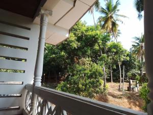 Holiday Home in Mirigama في Mirigama: منظر من شرفة منزل مع أشجار النخيل