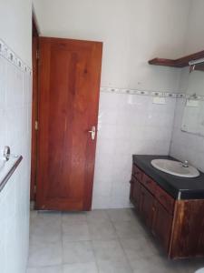 uma casa de banho com um lavatório e uma porta de madeira em Holiday Home in Mirigama em Mirigama
