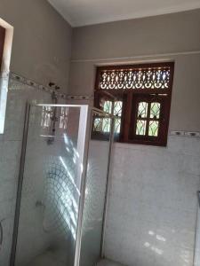 a bathroom with a shower and a glass shower stall at Holiday Home in Mirigama in Mirigama