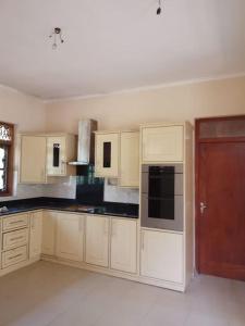 a kitchen with white cabinets and a brown door at Holiday Home in Mirigama in Mirigama