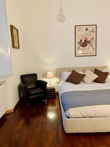 een slaapkamer met een bed en een zwarte stoel bij Casa al porto Sea port Apartment Ancona in Ancona