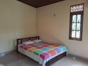 Holiday Home in Mirigama في Mirigama: غرفة نوم مع سرير ملون في غرفة