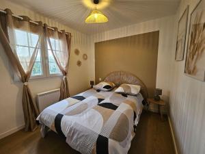 Schlafzimmer mit einem Bett mit einer schwarzen und weißen Bettdecke in der Unterkunft Maison 4 ch*L'Aiguillon s/ Mer in LʼAiguillon-sur-Mer
