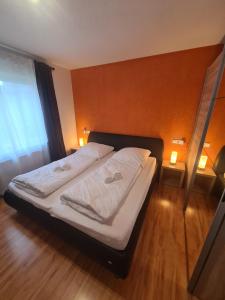 a bedroom with a bed with white sheets and a window at WellandHome- Deluxe Apartment Schechingen in Schechingen