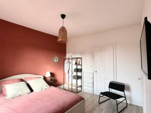 a bedroom with a bed and a black chair at L Étoilé Appartement tout confort à Epinal Gare Classé 3 étoiles in Épinal