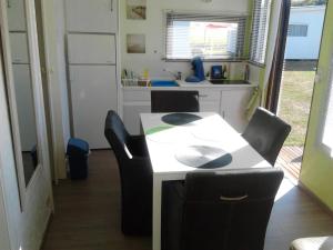cocina con mesa, sillas y barra en Noordzee 1 en De Haan