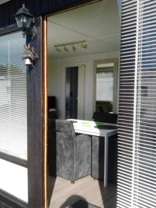 un bureau avec une table, une chaise et un miroir dans l'établissement Noordzee 1, au Coq