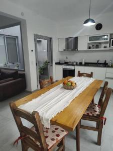 a wooden table in a kitchen with a bowl of fruit on it at Duplex Victoria in Luján