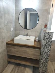 a bathroom with a white sink and a mirror at Duplex Victoria in Luján