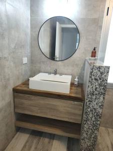 ein Badezimmer mit einem weißen Waschbecken und einem Spiegel in der Unterkunft Duplex Victoria in Luján + 21 Fotos