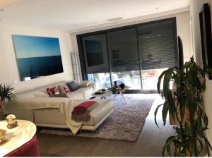 uma sala de estar com um sofá e uma grande janela em Oasis Familiar, casa con jardín con ubicación Ideal em Alcobendas