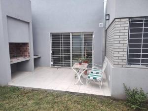 eine Terrasse mit Tisch und Stuhl neben einem Gebäude in der Unterkunft Duplex Victoria in Luján
