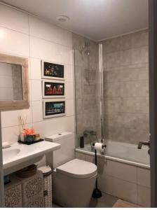 uma casa de banho com um WC, um lavatório e uma banheira em Oasis Familiar, casa con jardín con ubicación Ideal em Alcobendas