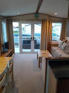 a living room with a couch and a table at Sunnymeade Holiday Park i3 St David in Ingoldmells
