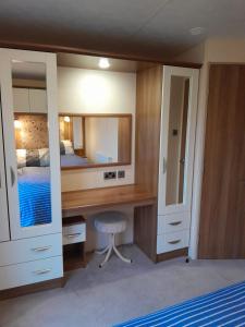 a bedroom with a desk and a bed and a mirror at Sunnymeade Holiday Park i3 St David in Ingoldmells