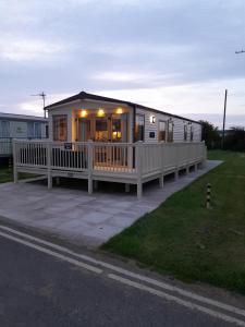 uma casa móvel com um alpendre e um deque em Sunnymeade Holiday Park i3 St David em Ingoldmells