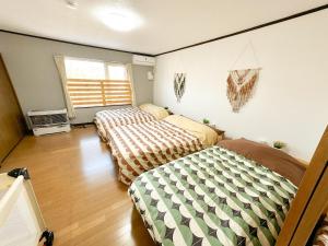 a bedroom with two beds and a window at Kaito/9min walk to Noboribetsu st. in Tomiura