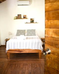 サンタ・テレサにあるCuatro Vientos Lodge & Apartmentsのベッドルーム1室(ベッド1台付)、木製のドア