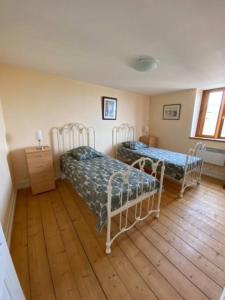 sypialnia z 2 łóżkami i drewnianą podłogą w obiekcie le Bed-Somme w mieście Saint-Valéry-sur-Somme
