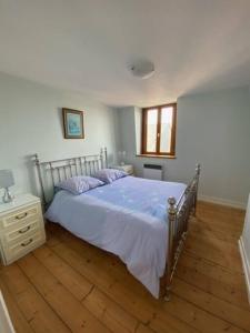 sypialnia z łóżkiem i drewnianą podłogą w obiekcie le Bed-Somme w mieście Saint-Valéry-sur-Somme
