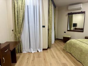 a bedroom with a bed and a dresser and a mirror at Rritja e Koranit in Pogradec