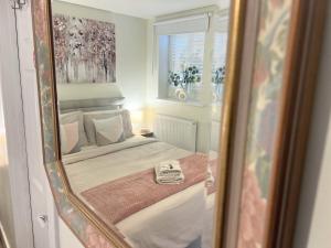 espejo reflejo de una cama en un dormitorio en Balcony Penthouse Room Basingstoke Hospital 2min drive and walkable, en Basingstoke