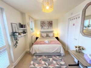 Dormitorio pequeño con cama y espejo en Balcony Penthouse Room Basingstoke Hospital 2min drive and walkable, en Basingstoke