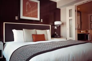 a hotel room with a large bed with white sheets at Oyo Hotel Luxury Inn Near Dhaula Kuan Delhi in New Delhi