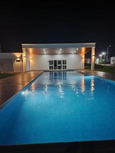 a large swimming pool at night with a building at Max´s House in Ahuachapán